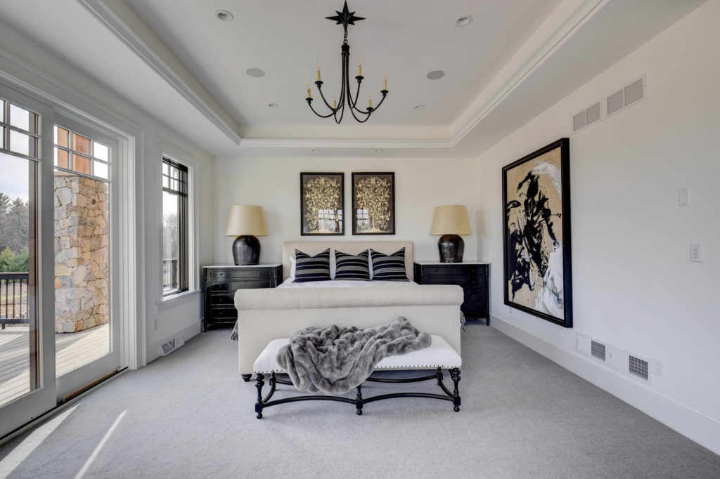 Elegant bedroom with black furniture and chandelier.