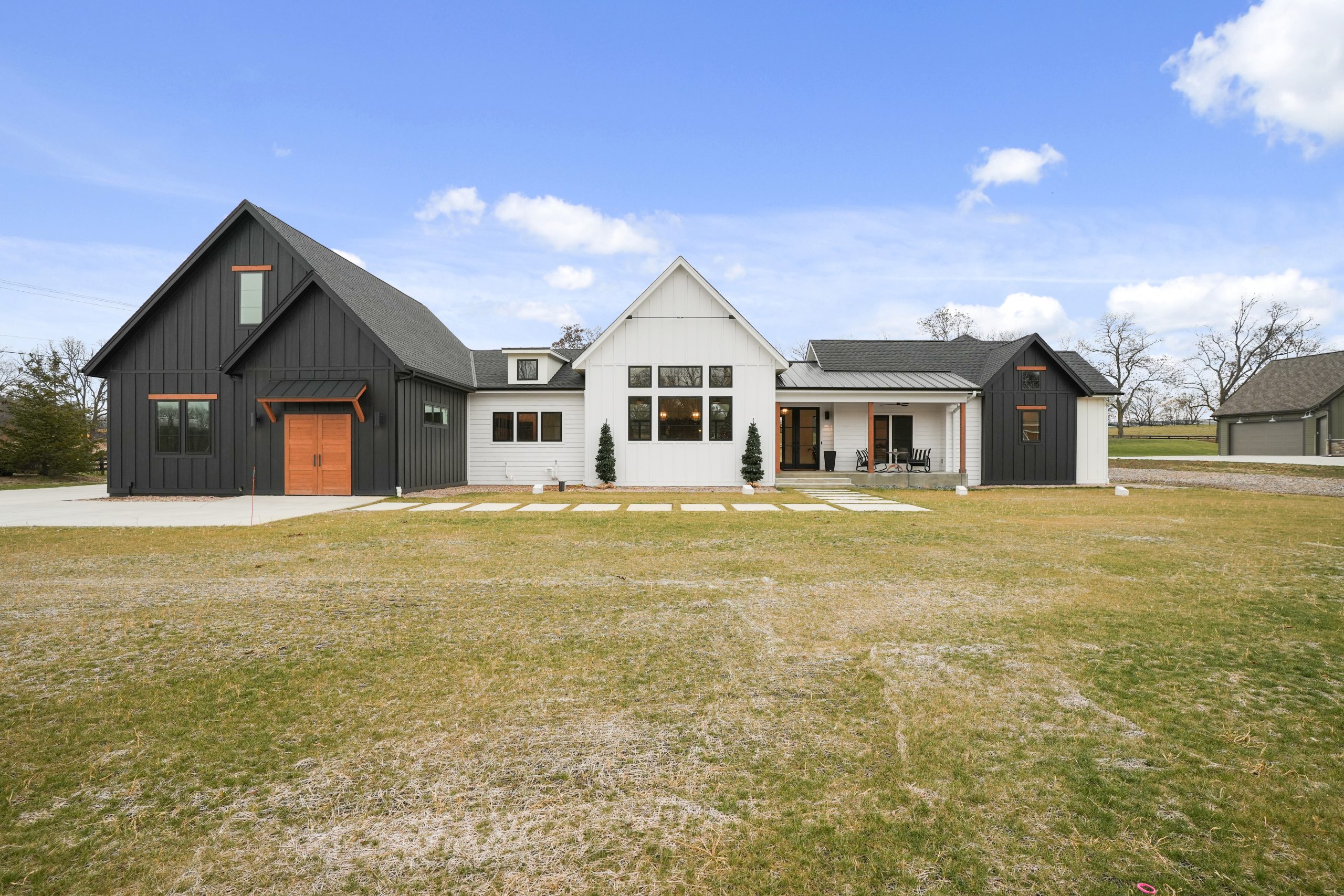 Modern farmhouse with mixed siding and attached garage.