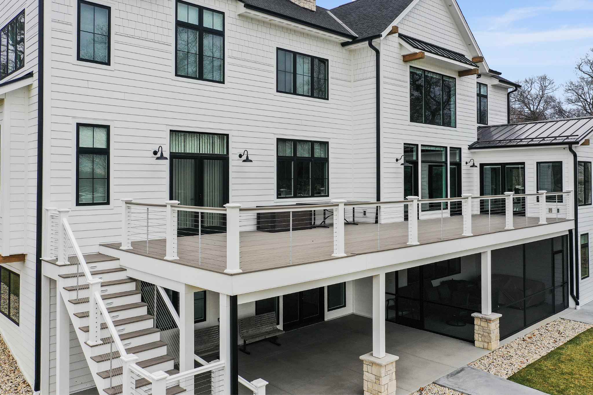 Luxury homes builder showcasing a modern two-story white house with an expansive balcony.