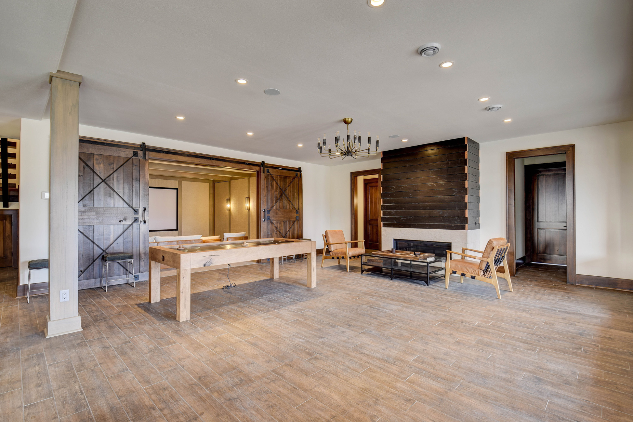 Spacious recreation room with barn doors and modern amenities in a luxury custom home.