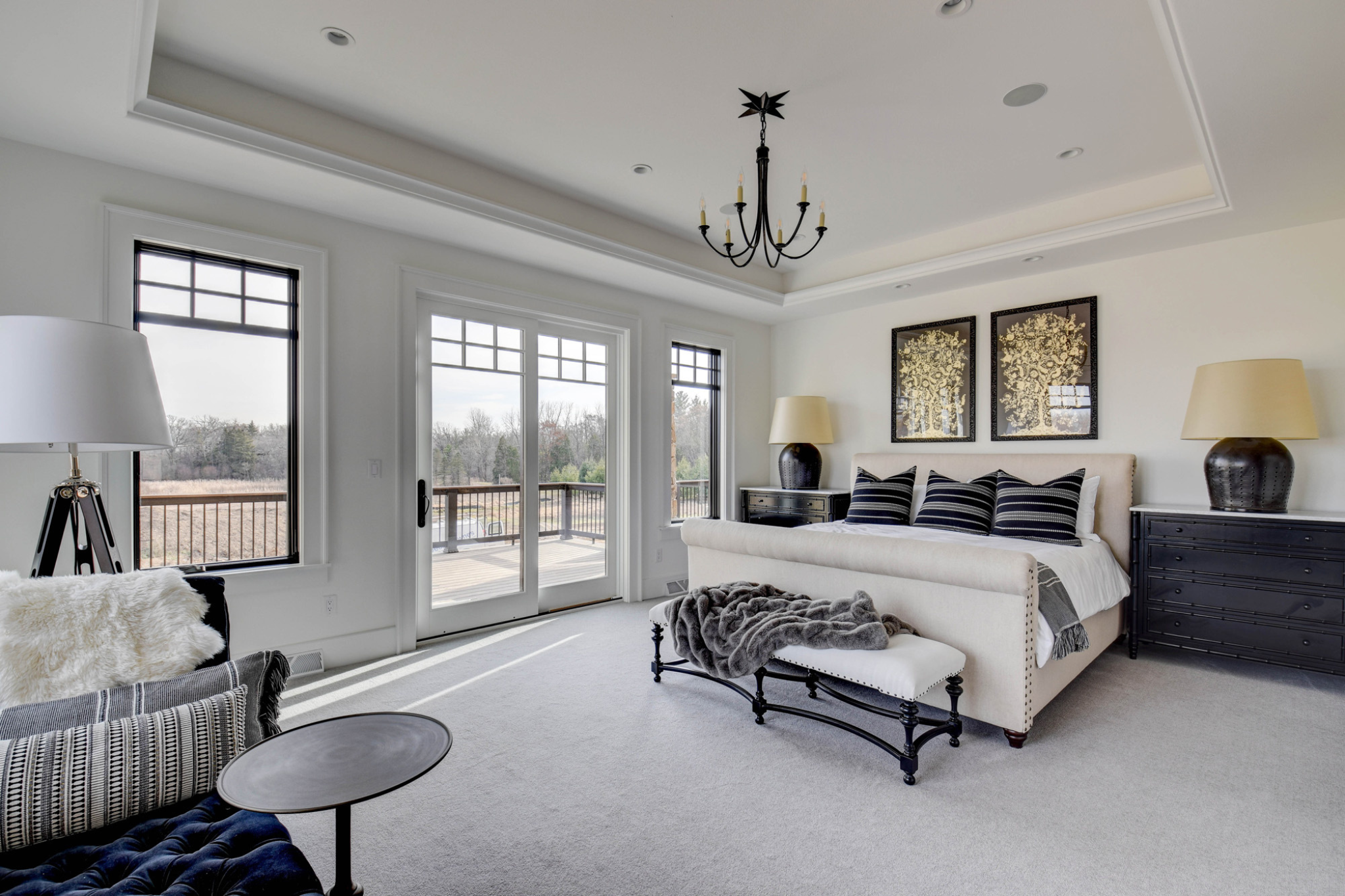 Luxurious bedroom with balcony access in a custom-built Pewaukee home.
