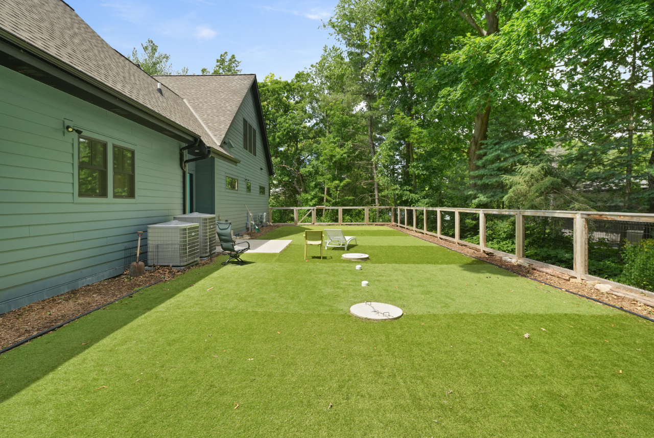 A spacious backyard designed by home builders in Waukesha, WI, featuring a lush green lawn and plenty of space for outdoor activities.