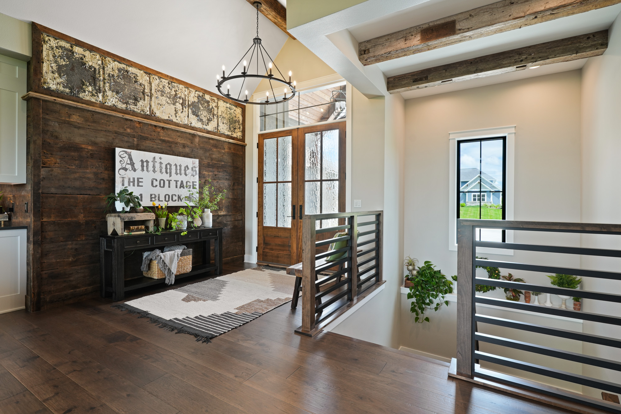 the inside of a custom build home, an entrance with bright lighting and wooden features.