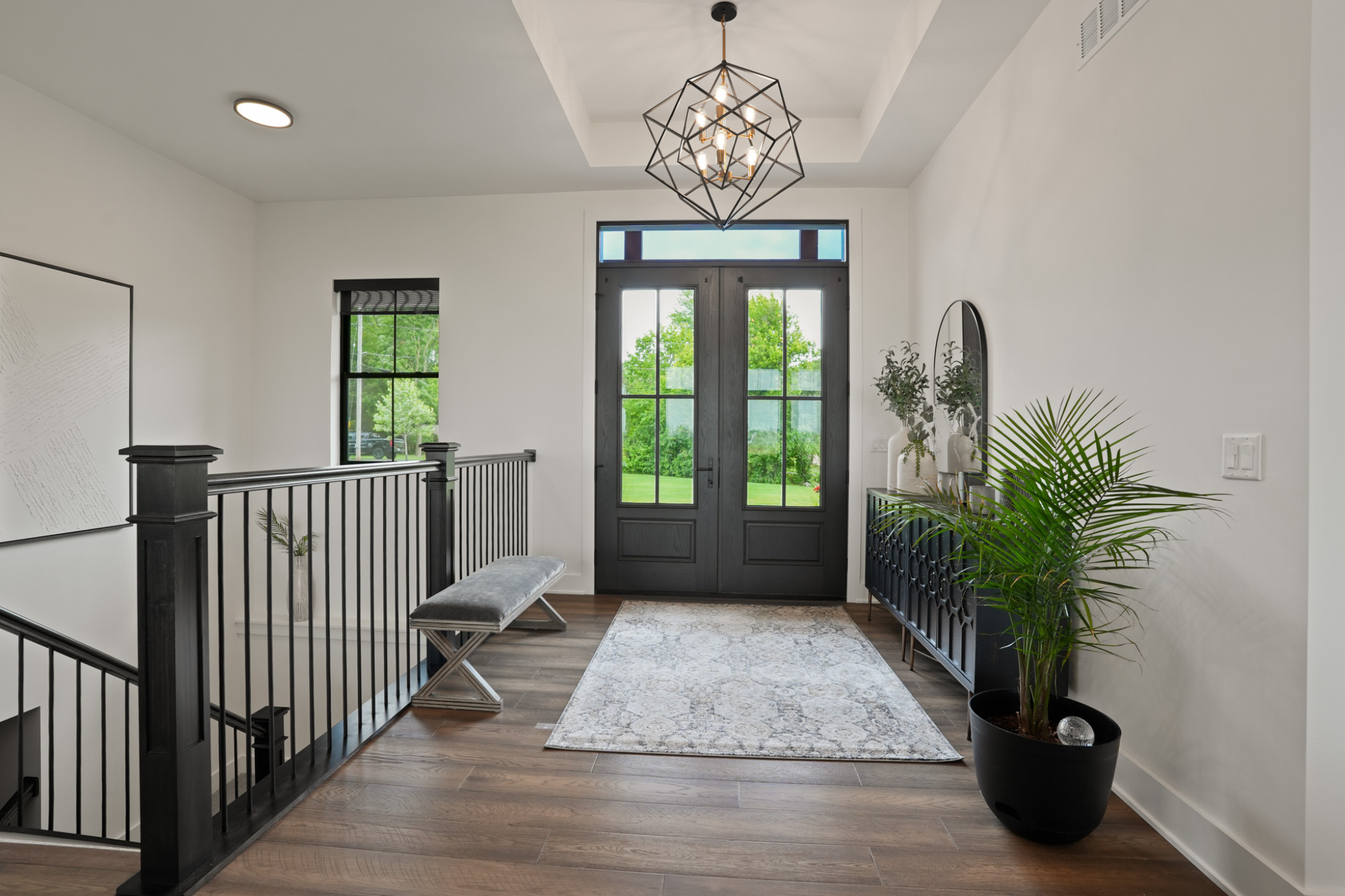 One story vs two story house: Modern entryway with elegant lighting and large glass doors.