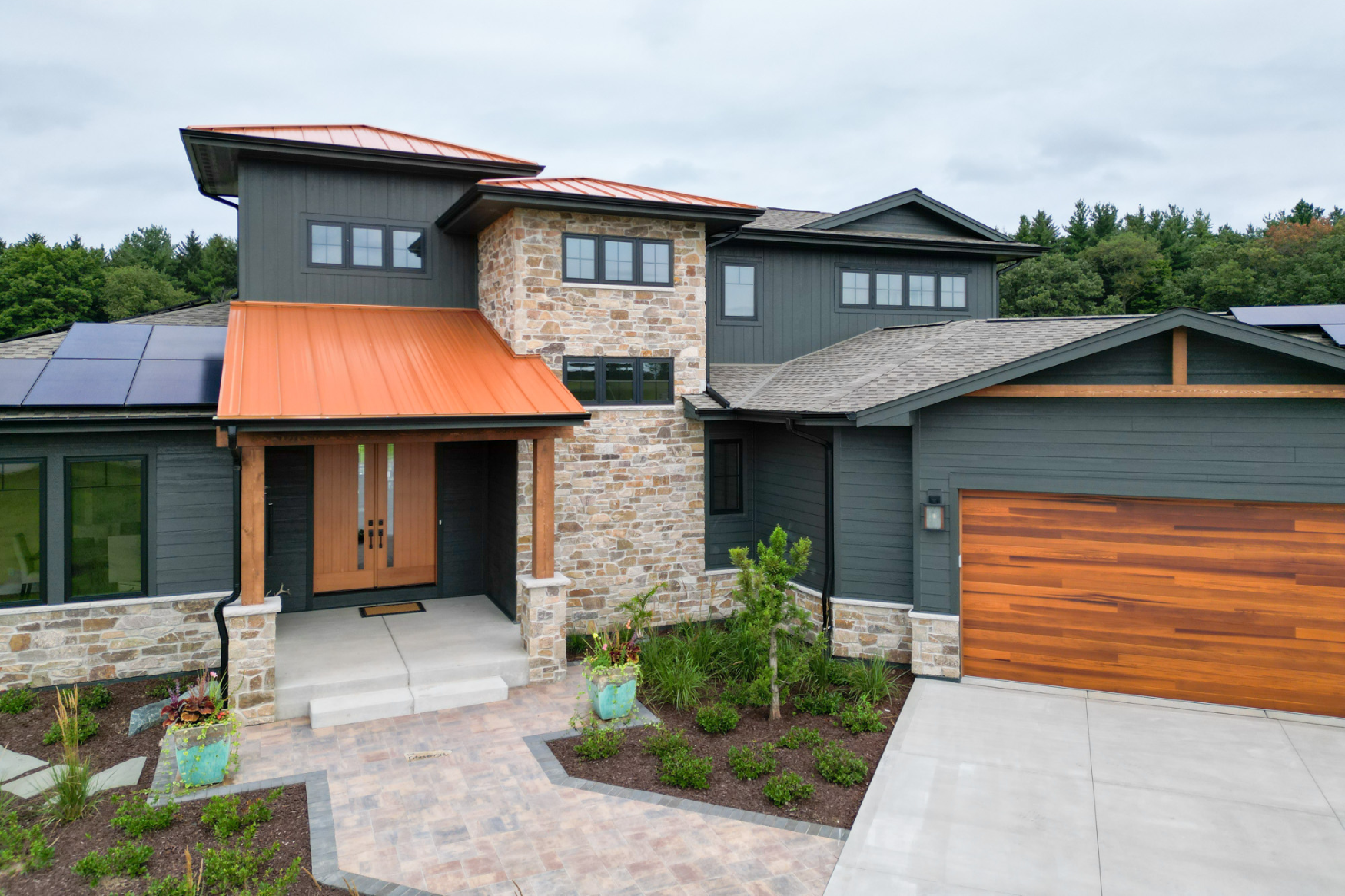 A custom-built home in Hartland, featuring a striking blend of stone and metal design elements, showcasing modern architectural flair.