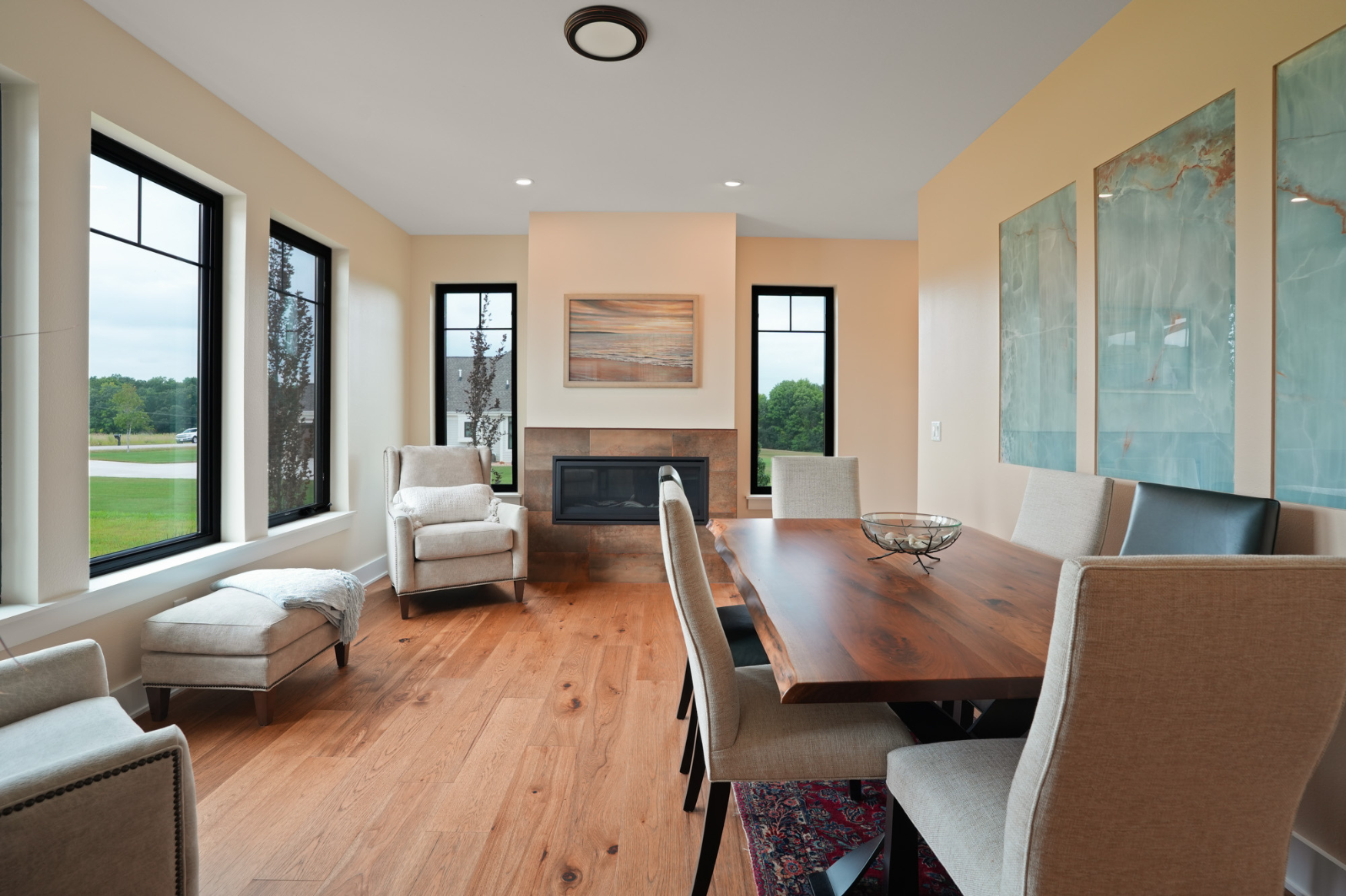 Spacious, light-filled dining room with floor-to-ceiling windows, exemplifying elegant custom home design in Hartland.