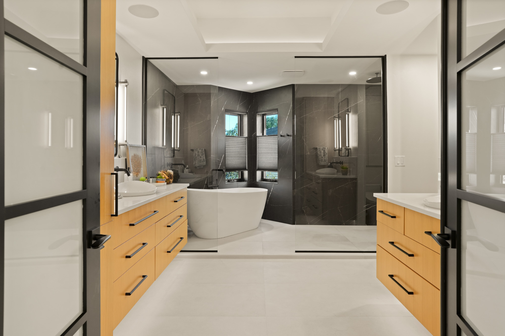 Spacious master bathroom with double vanities and freestanding tub, showcasing high-end custom home design in Pewaukee.