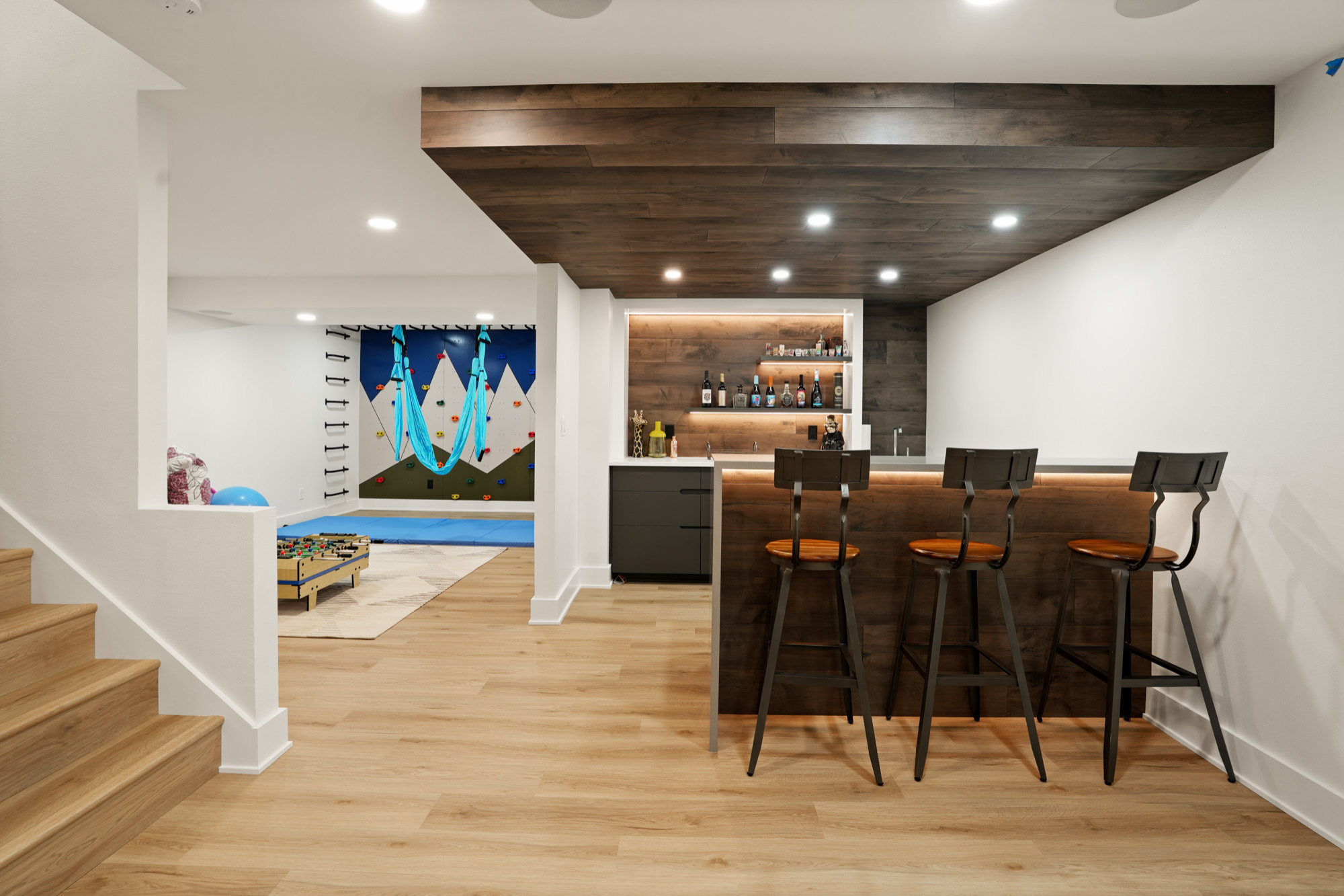 Custom-designed basement featuring a home bar and play area, crafted by expert home builders in Waukesha.