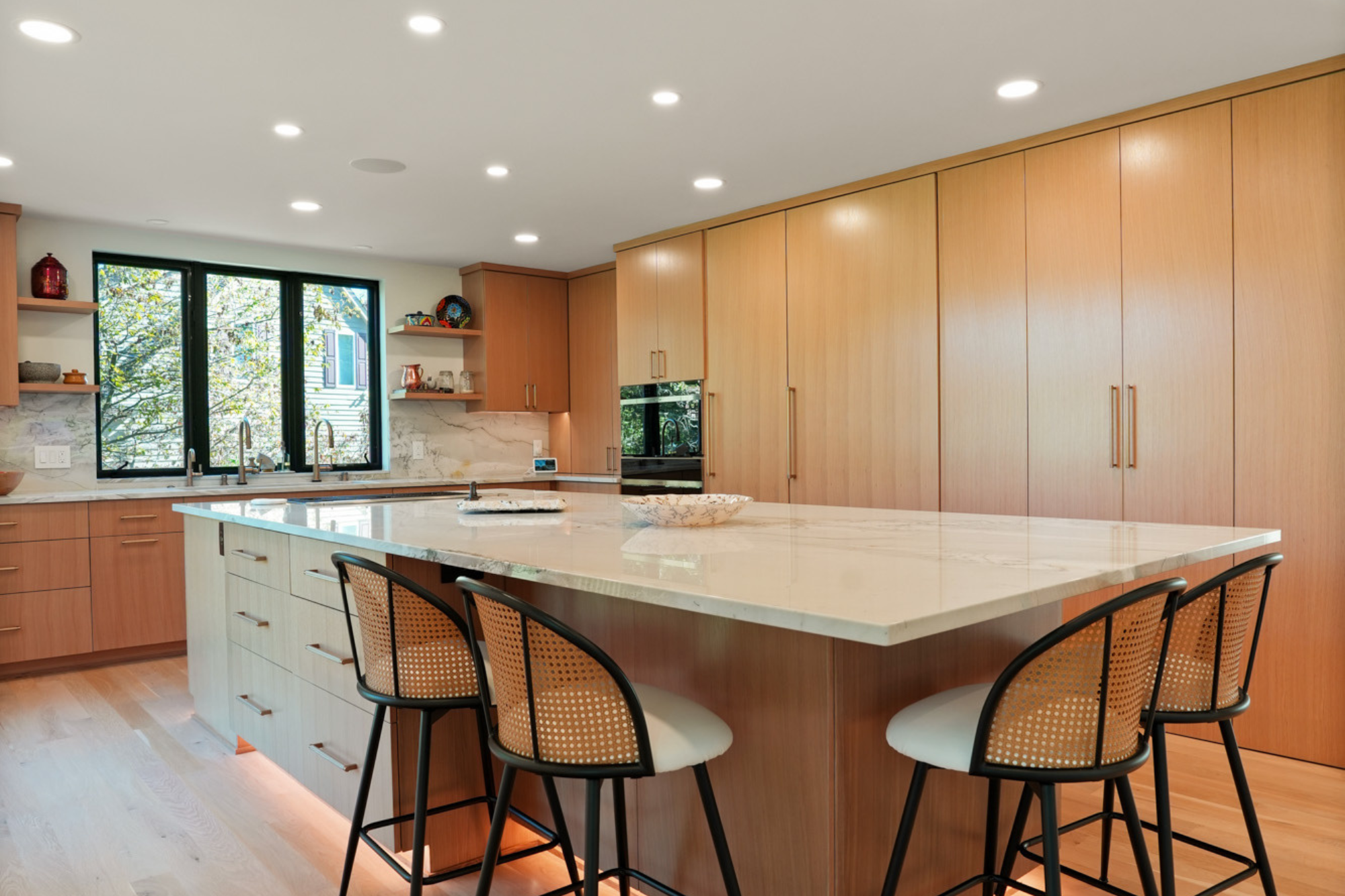 A modern kitchen with a large island and sleek cabinetry, showcasing the craftsmanship of home builders in Waukesha.