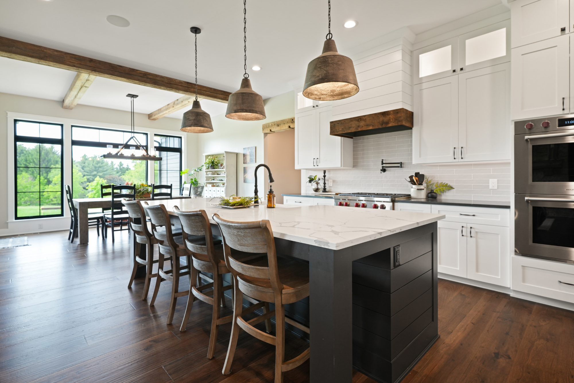 Spacious kitchen with a large island and rustic beams, highlighting custom craftsmanship by home builders in Waukesha WI.