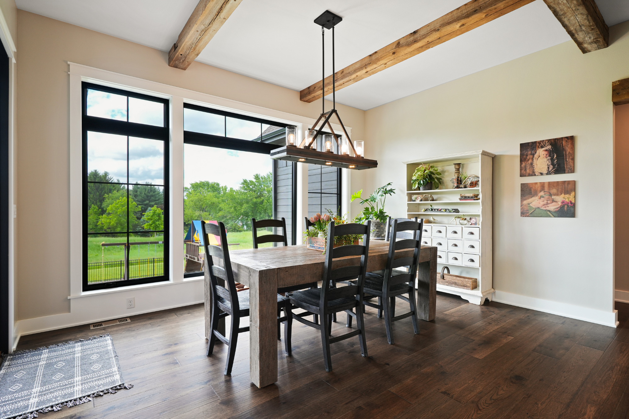 Bright dining room with large windows and wooden beams in a custom-built home by home builders in Waukesha WI.