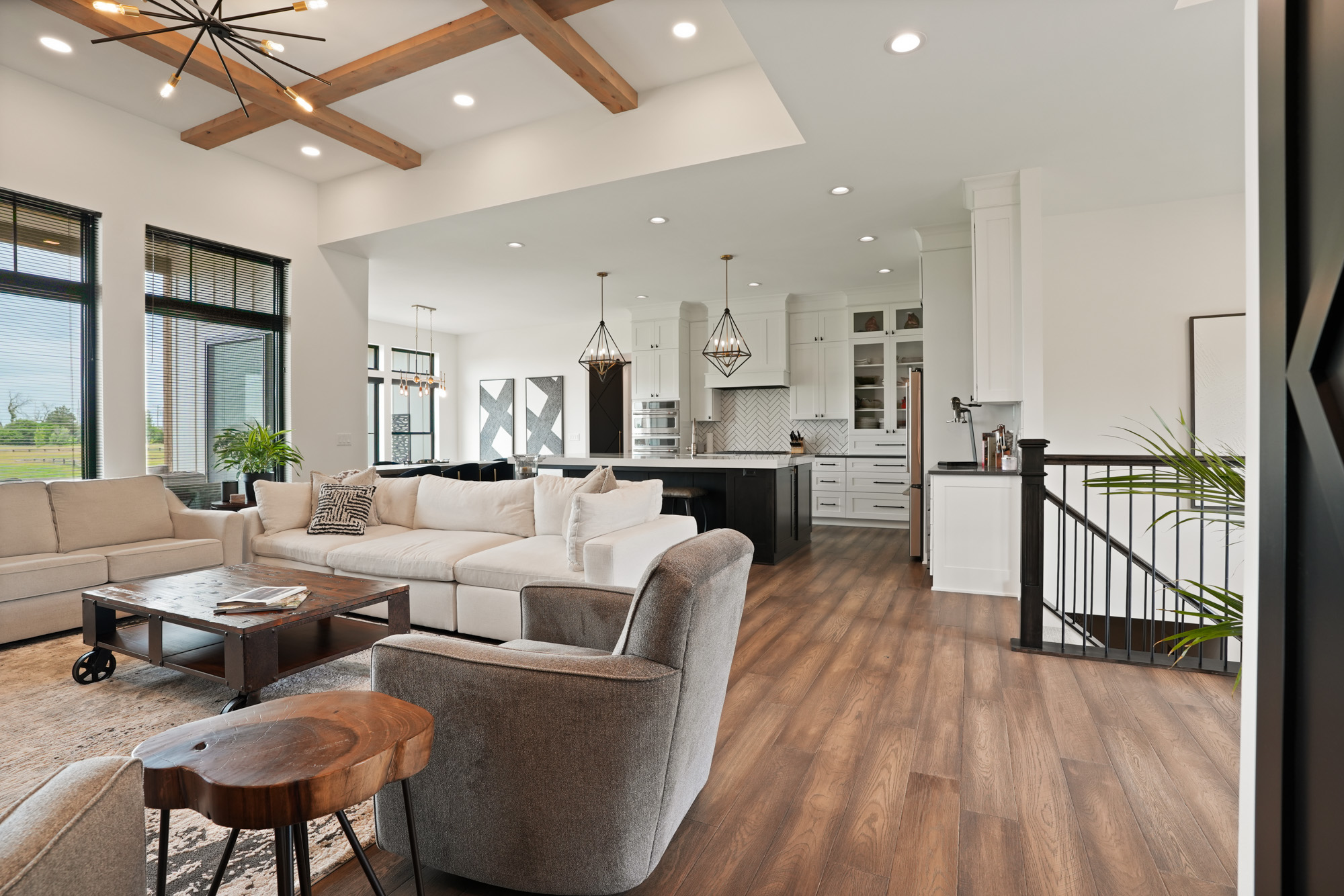 DSC08658 Spacious open-concept living room and kitchen with vaulted ceilings and exposed wood beams crafted by expert lake house builders in Wisconsin.