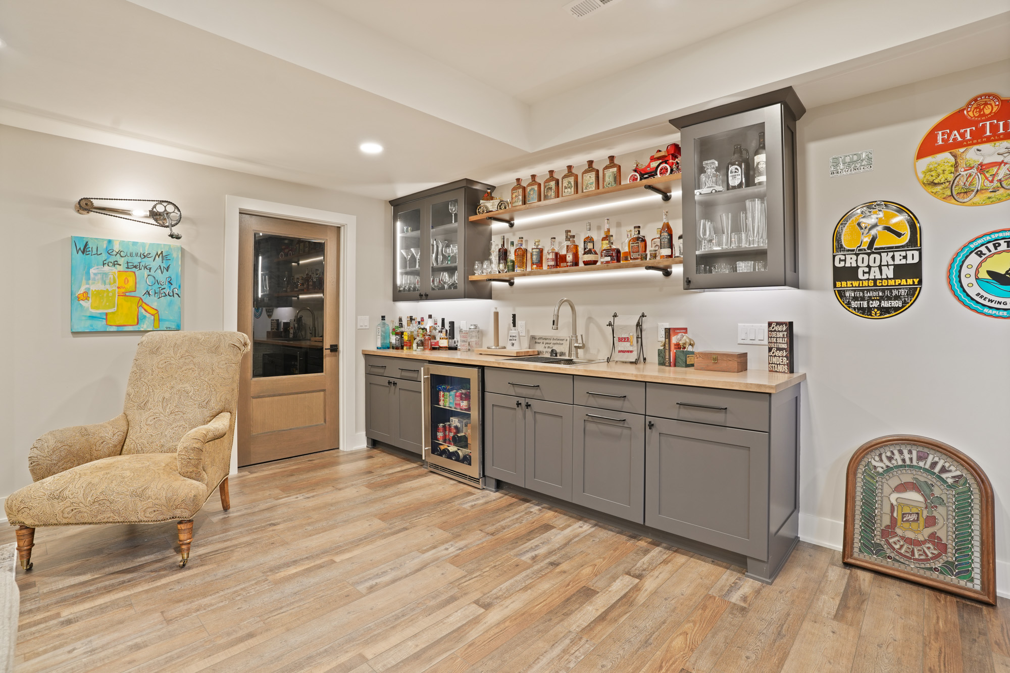 DSC08793 Custom home bar with wood flooring, open shelving, and glass cabinetry designed by lake house builders in Wisconsin for stylish entertaining.
